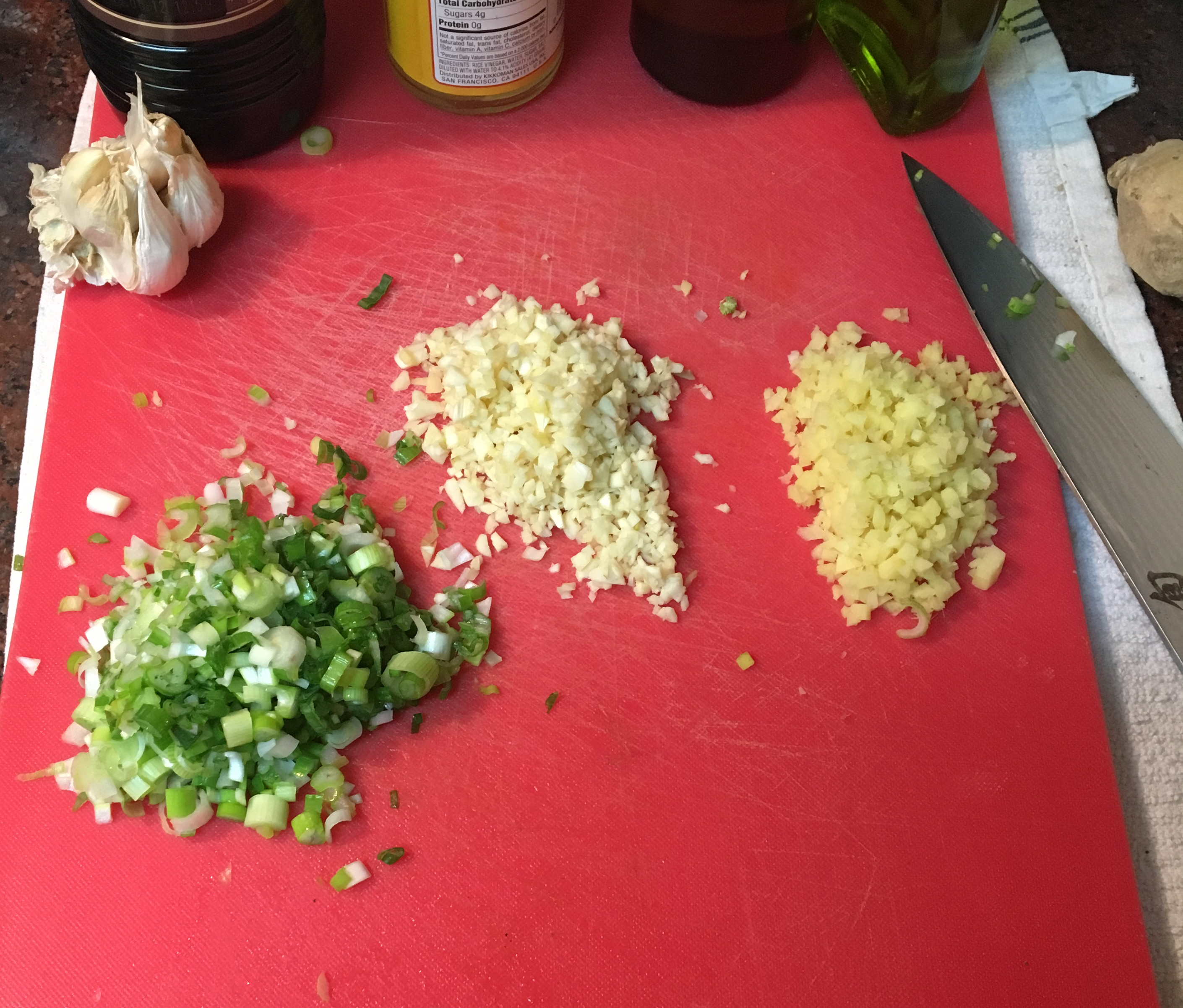 Three even piles of chopped, fresh ginger, garlic and scallion