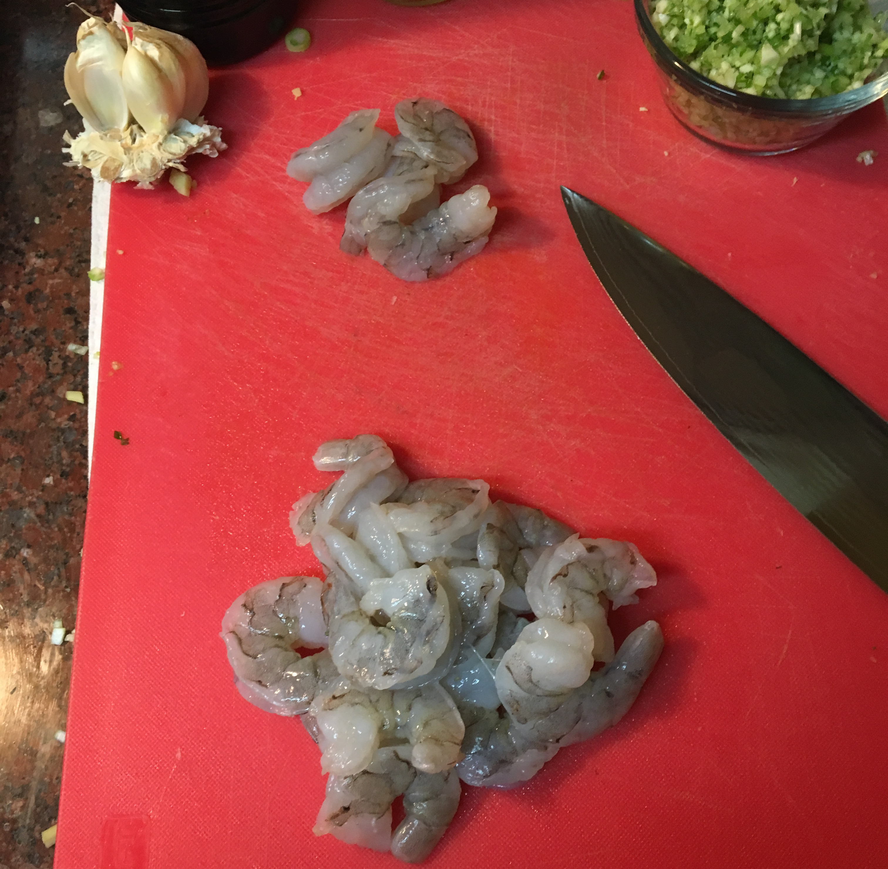 two piles of cleaned, peeled and deveined shrimp, one small and one large. 