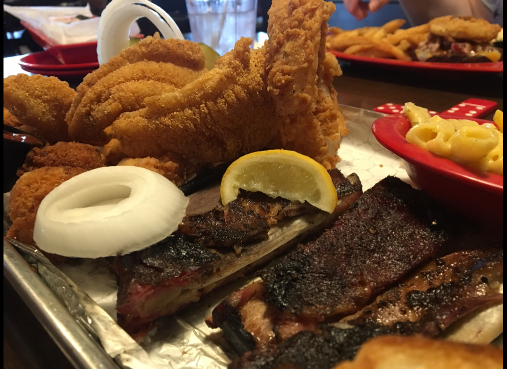 a tray stacked with catfish, shrimp and barbecued ribs